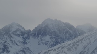 4K aerial stock footage snow covered Chugach Mountains fogged by low clouds, Alaska Aerial Stock Footage | AK0001_1496