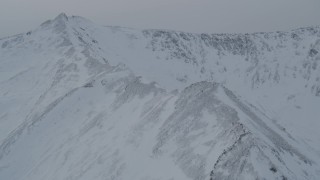 4K aerial stock footage flying up a snowy mountain slope to reveal a valley, Chugach Mountains, Alaska Aerial Stock Footage | AK0001_1502