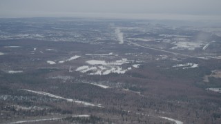 4K aerial stock footage flying over snowy wooded slopes revealing Anchorage, Chugach Mountains, Alaska Aerial Stock Footage | AK0001_1509