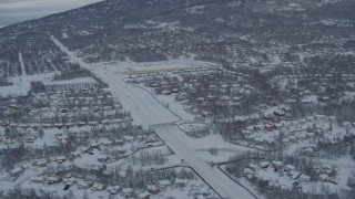 4K aerial stock footage following Eagle River Loop Road through snow covered forest, Alaska Aerial Stock Footage | AK0001_1535