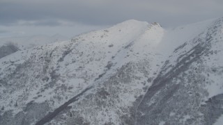 4K aerial stock footage tilting up a snow covered mountain slope, Chugach Mountains, Alaska Aerial Stock Footage | AK0001_1541