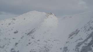 4K aerial stock footage flying over snowy summit, revealing range of Chugach Mountains, Alaska Aerial Stock Footage | AK0001_1542