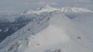 4K aerial stock footage flying over snowy mountain ridge toward summit, Chugach Mountains, Alaska Aerial Stock Footage | AK0001_1545