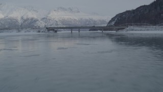 AK0001_1573 - 4K aerial stock footage flying over Knik River toward Old Glenn Highway bridges, Alaska in snow