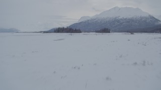 4K aerial stock footage fly over snowy ground toward Chugach Mountains, Knik River Valley, Alaska Aerial Stock Footage | AK0001_1589