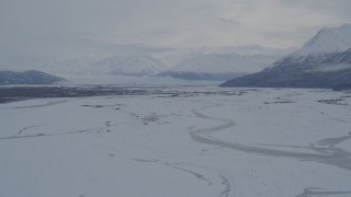 4K aerial stock footage Knik Glacier, Chugach Mountains seen from snowy Knik River Valley, Alaska Aerial Stock Footage | AK0001_1597