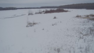 4K aerial stock footage flying low over frozen, snow covered ground, Knik River Valley, Alaska Aerial Stock Footage | AK0001_1599