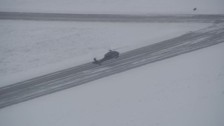 AK0001_1639 - 4K aerial stock footage track a helicopter landing at snowy Bryant Army Heliport, Anchorage, Alaska