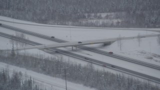 AK0001_1640 - 4K aerial stock footage cars on Glenn Highway past D Street overpass, Anchorage, Alaska in snow