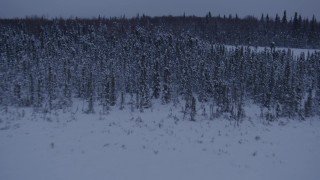 4K aerial stock footage flying over frozen, snowy ground and woods at twilight in Point MacKenzie, Alaska, reveal Downtown Anchorage Aerial Stock Footage | AK0001_1681