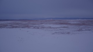 4K aerial stock footage flying low over frozen, snow covered ground at twilight, Point MacKenzie, Alaska Aerial Stock Footage | AK0001_1710