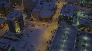 AK0001_1724 - 4K aerial stock footage following West 6th Avenue in snow covered Downtown Anchorage at night, Alaska