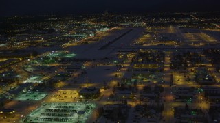 4K aerial stock footage flying toward snow covered Merrill Field at night, Anchorage, Alaska Aerial Stock Footage | AK0001_1736