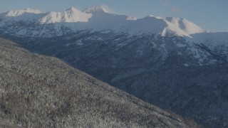 4K aerial stock footage flying over forested slopes toward snow capped Chugach Mountains, Alaska Aerial Stock Footage | AK0001_1743