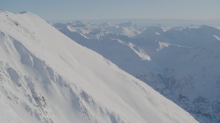 4K aerial stock footage rounding snowy slope toward mountain ranges in Chugach Mountains, Alaska Aerial Stock Footage | AK0001_1753