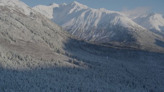 4K aerial stock footage flying over snowy, wooded valley at base of Chugach Mountains, Alaska Aerial Stock Footage | AK0001_1759