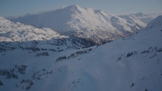 4K aerial stock footage flying over snowy ridge and rounding slope in Chugach Mountains, Alaska Aerial Stock Footage | AK0001_1764