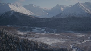 4K aerial stock footage wooded slopes and river valley, tilt up to snow capped Chugach Mountains, Alaska Aerial Stock Footage | AK0001_1766