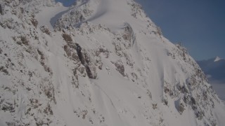 4K aerial stock footage rounding snow covered slopes in Chugach Mountains, Alaska Aerial Stock Footage | AK0001_1777