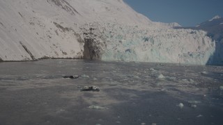 AK0001_1798 - 4K aerial stock footage flying low over icy surface of Harriman Fjord toward snow covered glacier, Alaska