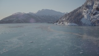 AK0001_1828 - 4K aerial stock footage fly low over surface of Harriman Fjord surrounded by snowy mountains, Alaska