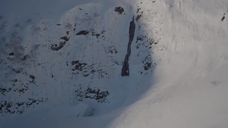 4K aerial stock footage approaching a waterfall on a snowy mountain, Chugach Mountains, Alaska Aerial Stock Footage | AK0001_1892