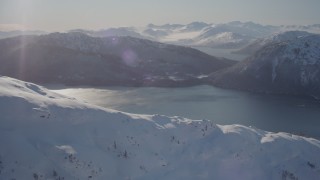 4K aerial stock footage flying over snow covered mountain toward Pigot Bay, Alaska Aerial Stock Footage | AK0001_1895