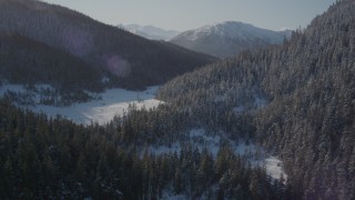 4K aerial stock footage flying over snowy shore of Pigot Bay toward forested slopes, Alaska Aerial Stock Footage | AK0001_1898