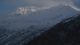 4K aerial stock footage rounding snowy, wooded slopes in the Chugach Mountains, Alaska Aerial Stock Footage | AK0001_1928