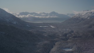 4K aerial stock footage flying over a wooded valley between snowy Chugach Mountains, Girdwood, Alaska Aerial Stock Footage | AK0001_1956