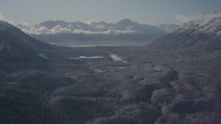 4K aerial stock footage fly over wooded valley between snowy Chugach Mountains, Girdwood, Alaska Aerial Stock Footage | AK0001_1957