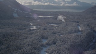 AK0001_1958 - 4K aerial stock footage tilt up revealing Girdwood Airport and snow covered Kenai Mountains, Alaska