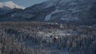 AK0001_1961 - 4K aerial stock footage approach snowy Alyeska Resort surrounded by forest, Girdwood, Alaska