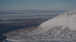 4K aerial stock footage flying toward a snowy mountain with cloud covered Anchorage, Alaska Aerial Stock Footage | AK0001_2000