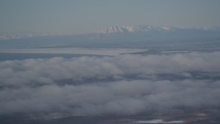 4K aerial stock footage snowy Mount Susitna near Point MacKenzie, clouds covering Anchorage, Alaska Aerial Stock Footage | AK0001_2003