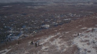 4K aerial stock footage flying over a snowy hill toward a residential neighborhood in Anchorage, Alaska Aerial Stock Footage | AK0001_2005