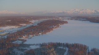 AK0001_2076 - 4K aerial stock footage Lucile Lake, moon over snowy Chugach Mountains at sunset, Wasilla, Alaska