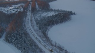 4K aerial stock footage a snow covered train running around Jacobsen Lake at twilight, Wasilla, Alaska Aerial Stock Footage | AK0001_2081