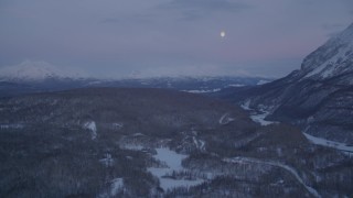 AK0001_2114 - 4K aerial stock footage snowy Thirtymile Lake, moon over snowy Talkeetna Mountains, Alaska, twilight