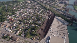 AX0001_007 - Aerial stock footage of 4.8K aerial  video  flying away from Chicago Skyway, neighborhood, and warehouses by the river, East Side Chicago, Illinois