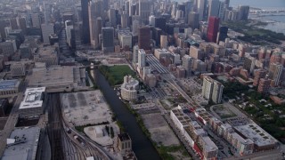 AX0001_078 - 4.8K aerial stock footage tilting from Metra Railroad Yard and Chicago River, reveal hazy Downtown Chicago, Illinois