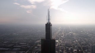 4.8K aerial stock footage of the top of the Willis Tower on a hazy day, Downtown Chicago, Illinois Aerial Stock Footage | AX0001_083