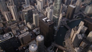 AX0001_084 - 4.8K aerial stock footage of Bird's eye of Marina City and Chicago River, tilt up revealing skyscrapers, on a hazy day, Illinois