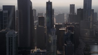 4.8K aerial stock footage flying by downtown Chicago skyscrapers, revealing Jay Pritzker Pavilion, on a hazy day, Illinois Aerial Stock Footage | AX0001_094