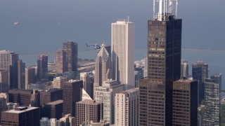 4.8K aerial stock footage of a helicopter hovering near Willis Tower Skydeck in Downtown Chicago, on a hazy day, Illinois Aerial Stock Footage | AX0001_112