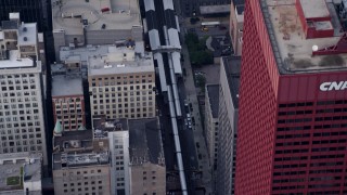 AX0001_146 - 4.8K aerial stock footage tracking an L Train stopping at a downtown station in Downtown Chicago, Illinois