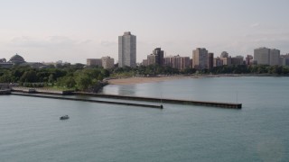 AX0002_002 - 4.8K aerial stock footage flying over piers on Lake Michigan toward a beach and apartment buildings in Hyde Park, Chicago, Illinois