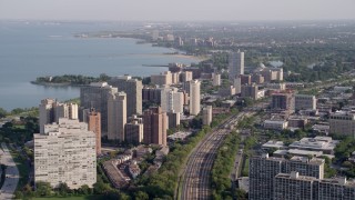 4.8K aerial stock footage of following train tracks by Hyde Park apartment buildings, Chicago, Illinois Aerial Stock Footage | AX0002_094