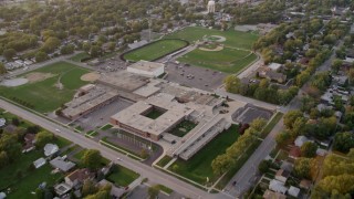 AX0003_001 - 4.8K aerial stock footage tilt and flyby Thornton Fractional South High School in Lansing, at sunset, Lansing, Illinois