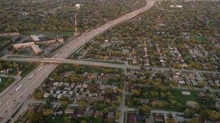 4.8K aerial stock footage of flying over residential neighborhoods and Kingery Expressway in Lansing, at sunset, Illinois Aerial Stock Footage | AX0003_003